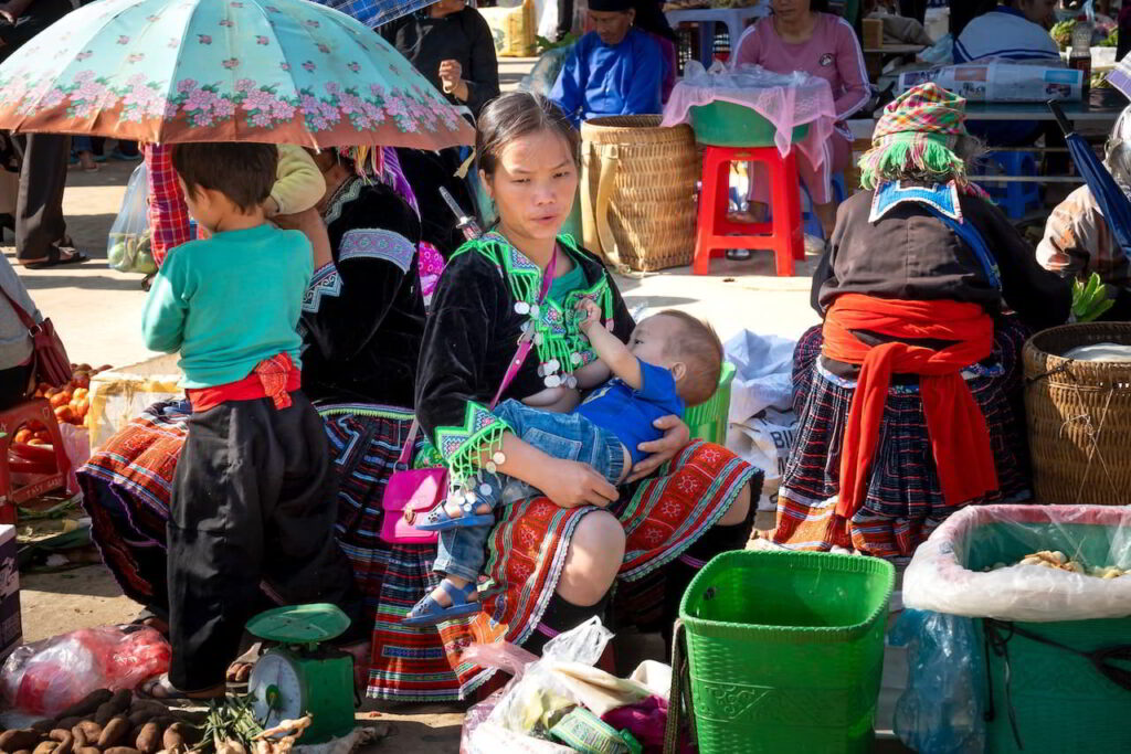 Lady breastfeeding a child in a market