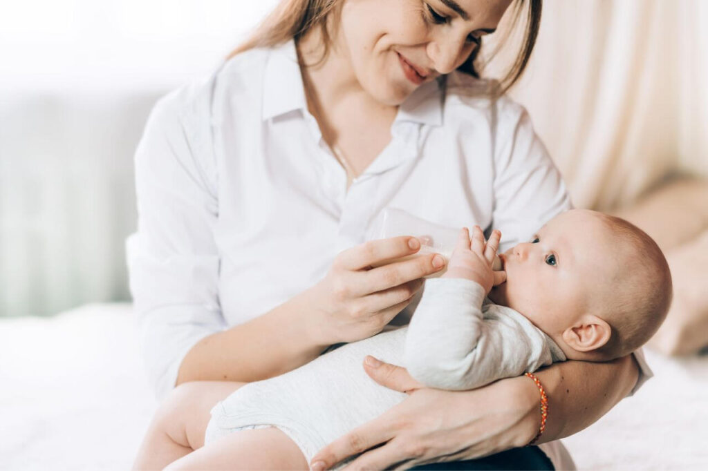 Caring Mother Bottle Feeds Her Newborn Baby
