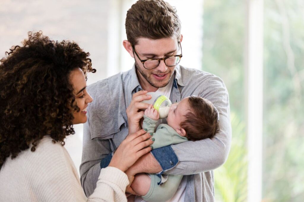 Young Dad feeds newborn son