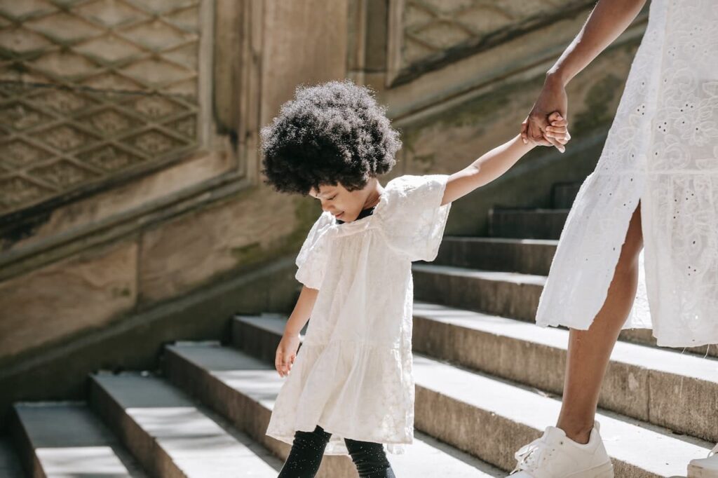 A mother and her daughter walking down a staircase